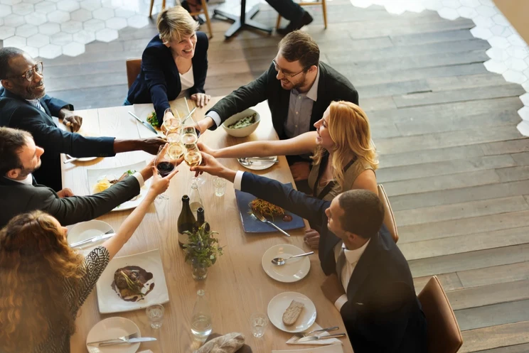 Attendees toasting at a networking dinner table